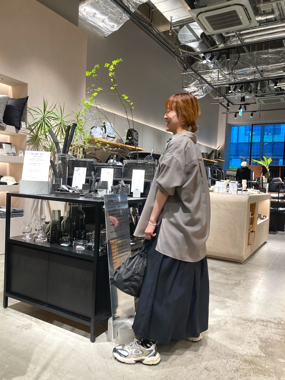 グレー系のシャツ/ブラウス、ブラック系のワンピース、ブラック系のショルダーバッグを着用したレディースの春コーディネートの3枚目の写真