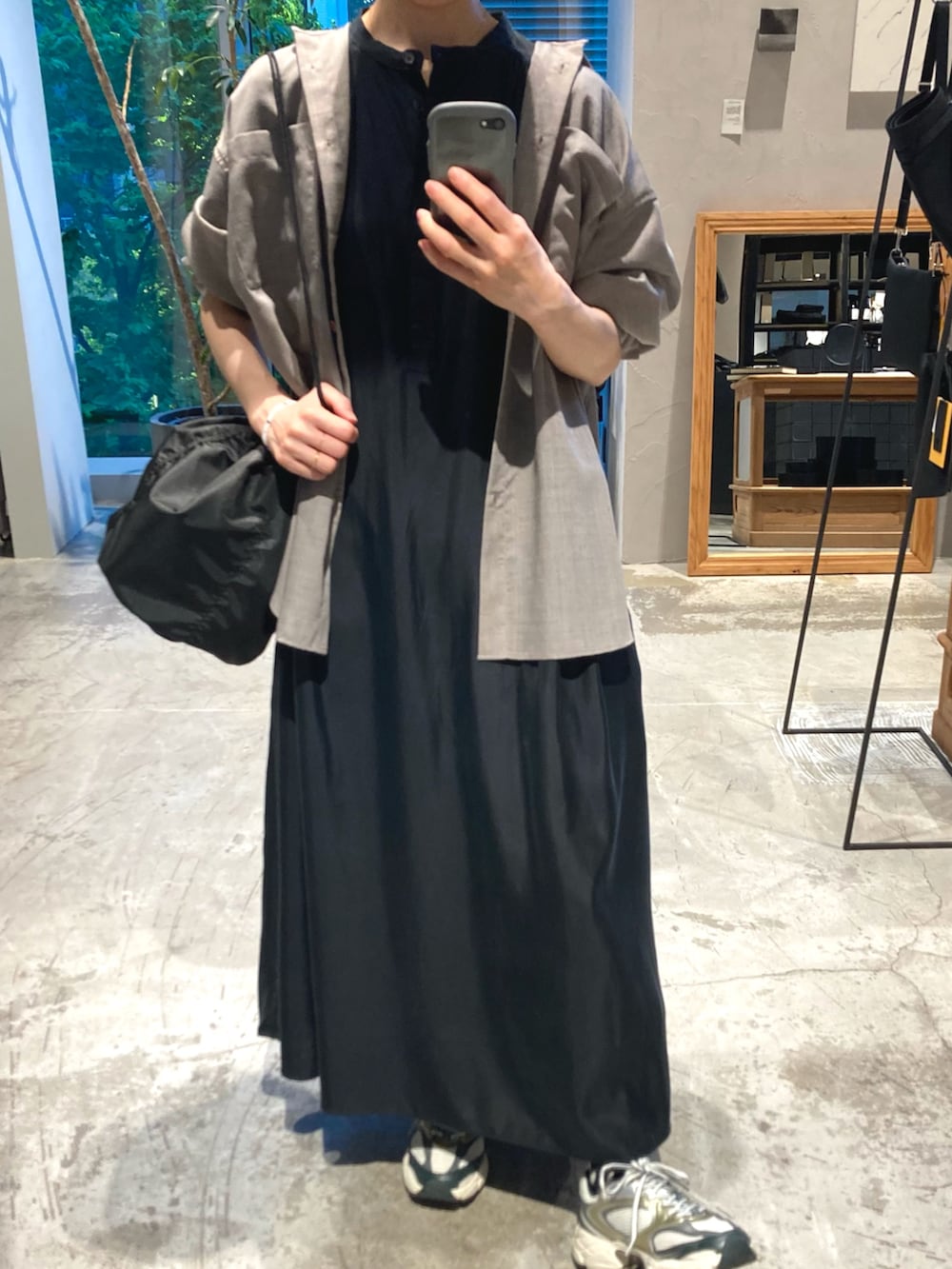 グレー系のシャツ/ブラウス、ブラック系のワンピース、ブラック系のショルダーバッグを着用したレディースの春コーディネートの2枚目の写真