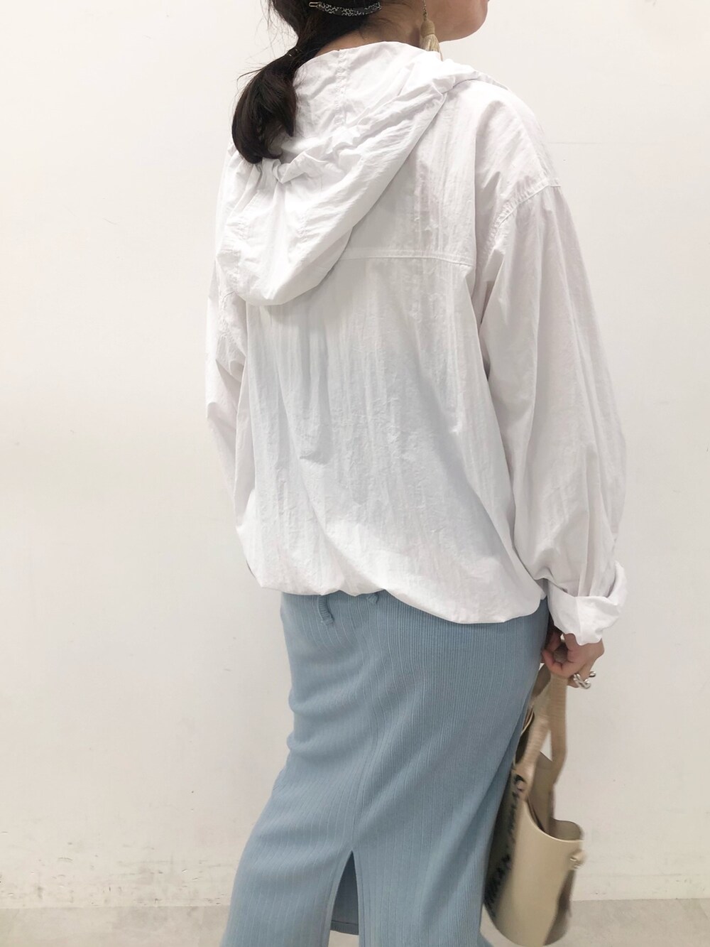 ホワイト系のパーカー、ブラック系のショルダーバッグを着用したレディースの夏コーディネートの4枚目の写真