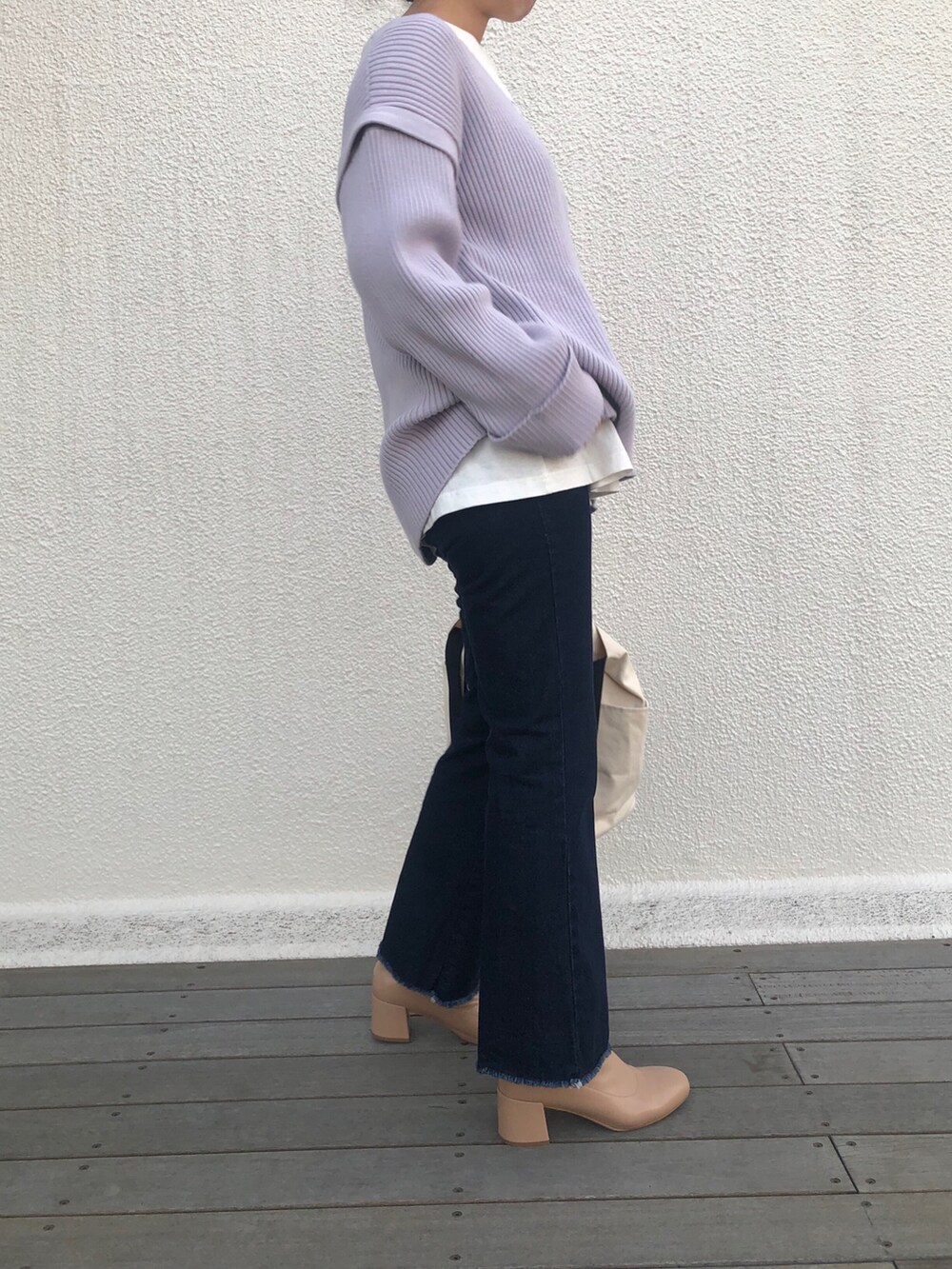 パープル系のニット/セーター、ベージュ系のブーツ、ホワイト系のショルダーバッグを着用したレディースの冬コーディネートの2枚目の写真