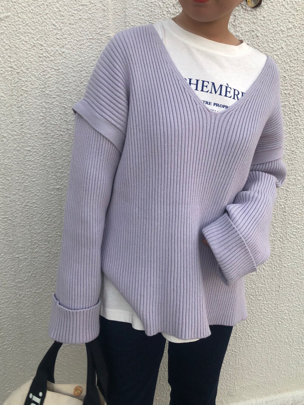 パープル系のニット/セーター、ベージュ系のブーツ、ホワイト系のショルダーバッグを着用したレディースの冬コーディネートの3枚目の写真