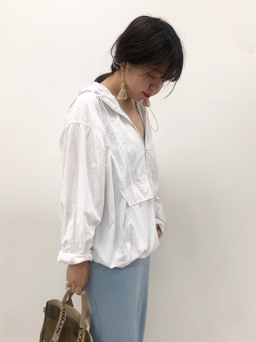 ホワイト系のパーカー、ブラック系のショルダーバッグを着用したレディースの夏コーディネートの3枚目の写真