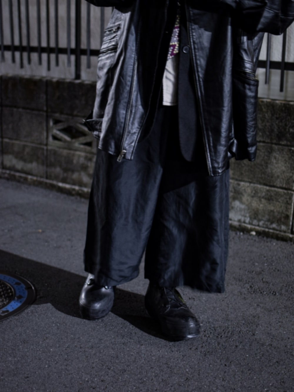 ブラック系のブーツ、ブラック系のスラックス、ブラック系のライダースジャケットを着用したメンズの春コーディネートの3枚目の写真