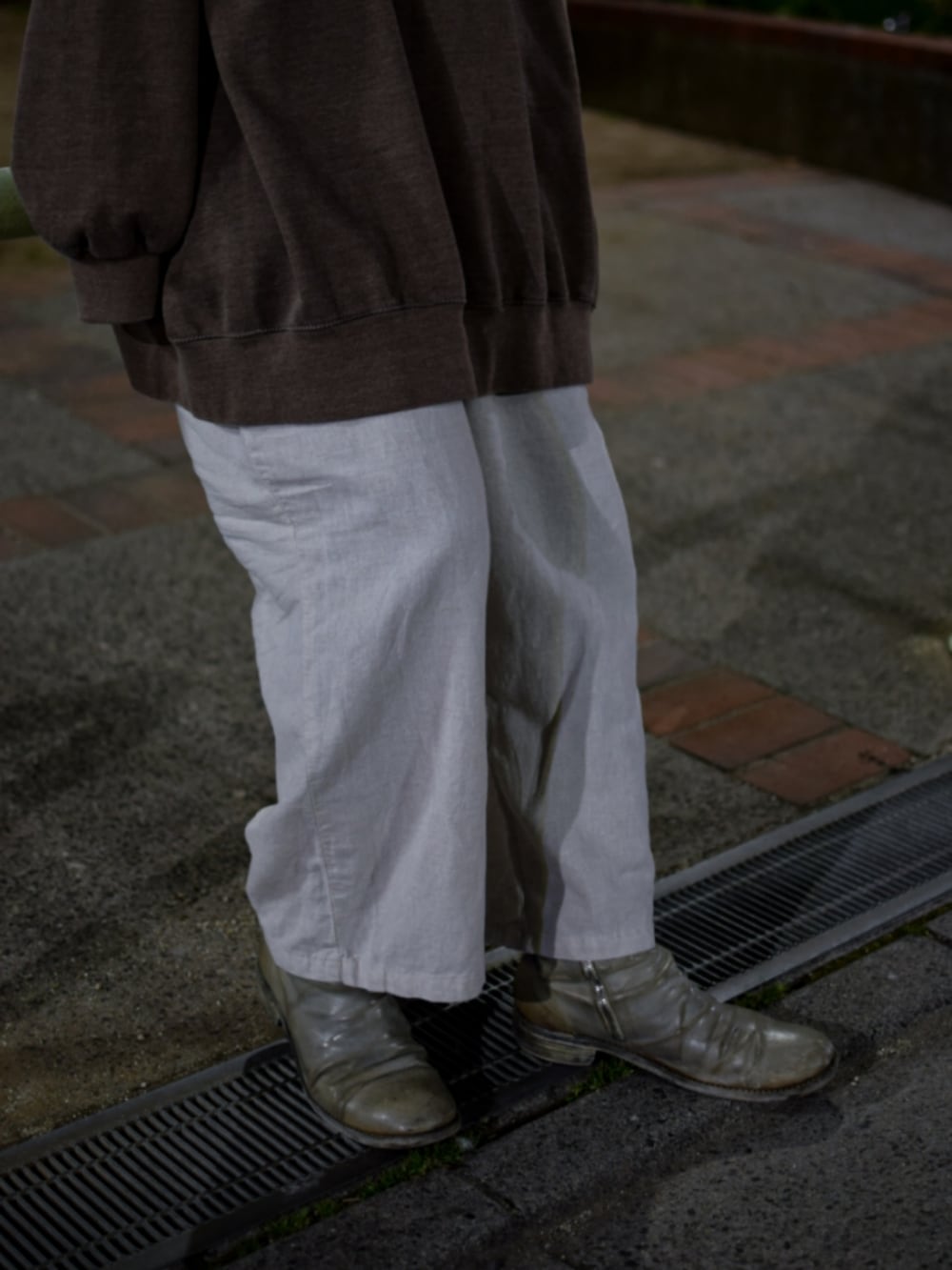 ブラウン系のスウェット、ベージュ系のパーカー、ホワイト系のその他パンツを着用したメンズの春コーディネートの3枚目の写真