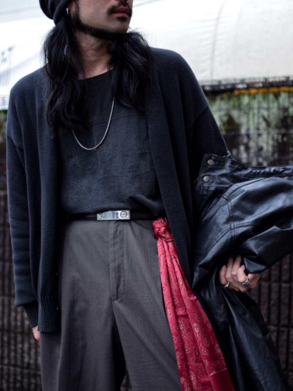 ブラック系のミリタリージャケット、ブラック系のTシャツ/カットソー、ブラウン系のスラックスを着用したメンズの春コーディネートの3枚目の写真