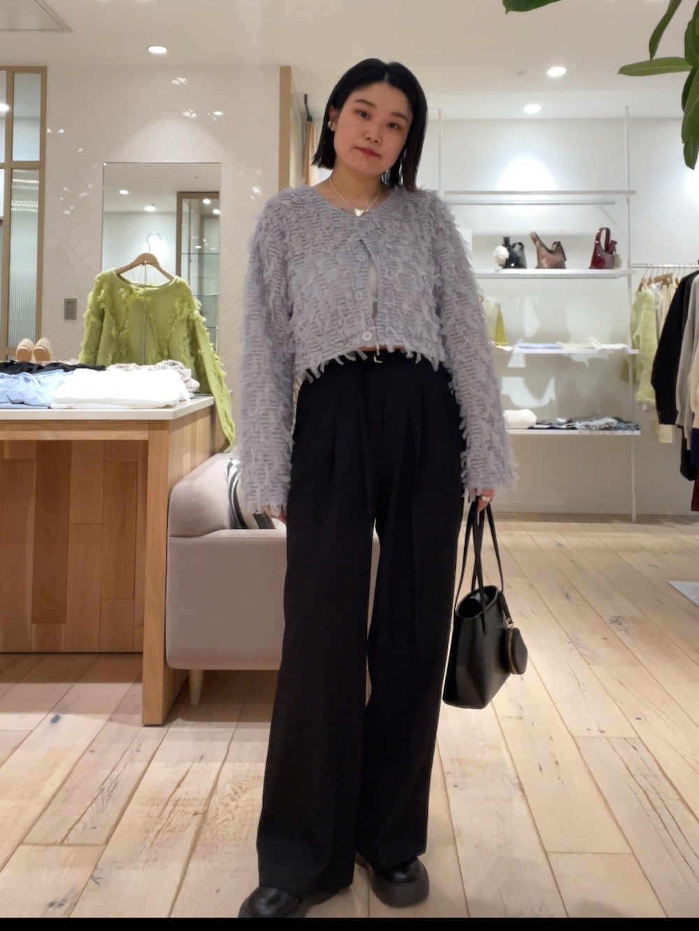 ブルー系のカーディガン/ボレロ、ブラック系のパンツを着用したレディースの冬コーディネートの2枚目の写真