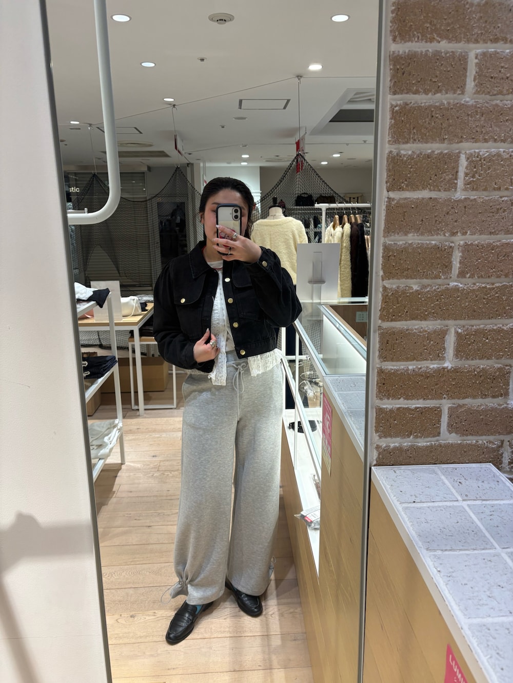 ブラック系のブルゾン、ホワイト系のシャツ/ブラウス、ホワイト系のパンツを着用したレディースの冬コーディネートの2枚目の写真