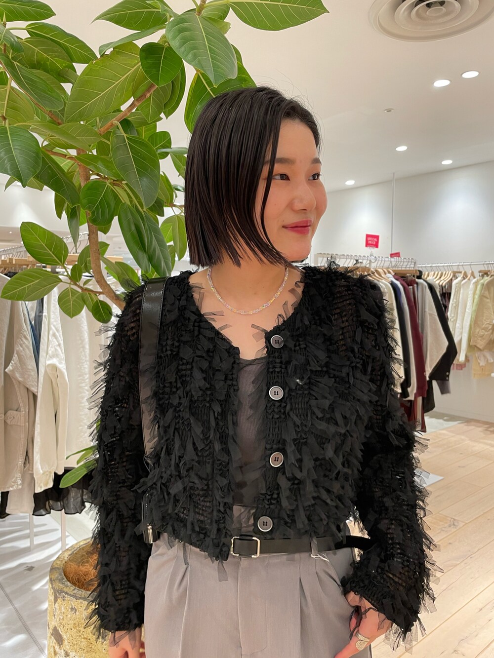 ブラック系のカーディガン/ボレロ、グレー系のスラックスを着用したレディースの冬コーディネートの2枚目の写真