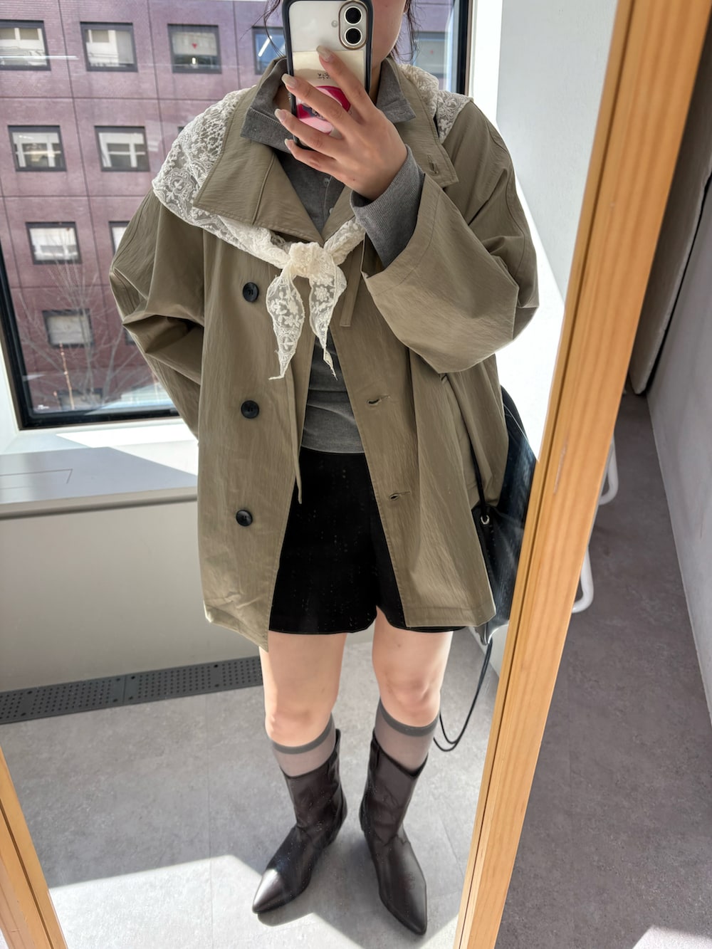 ブラウン系のブーツ、ベージュ系のトレンチコート、ホワイト系のTシャツ/カットソーを着用したレディースの冬コーディネートの3枚目の写真