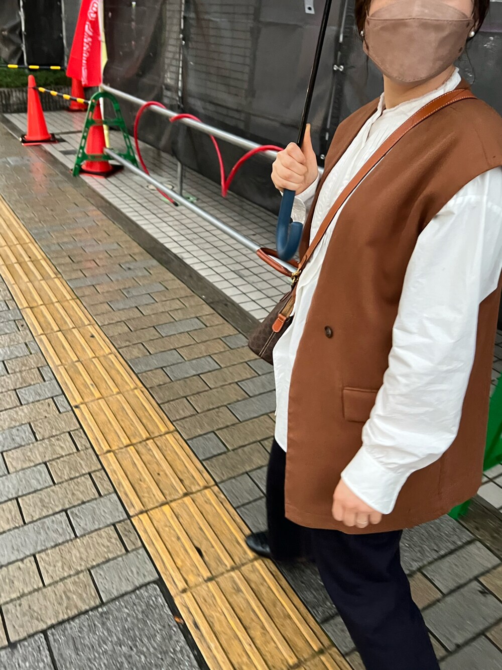 ブラウン系のベスト、ブラウン系のトートバッグ、その他のデニムパンツを着用したレディースの春コーディネートの2枚目の写真