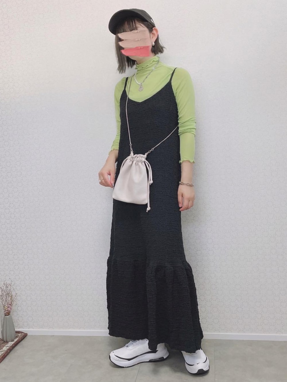 グリーン系のTシャツ/カットソー、ブラック系のワンピース、ホワイト系のスニーカーを着用したレディースの夏コーディネートの2枚目の写真