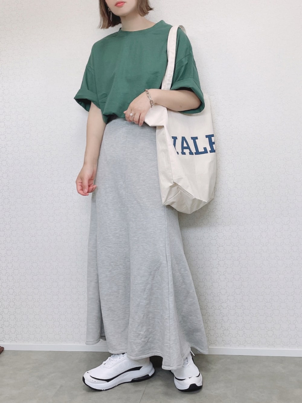 グリーン系のTシャツ/カットソー、ホワイト系のトートバッグ、グレー系のスカートを着用したレディースの春コーディネートの2枚目の写真