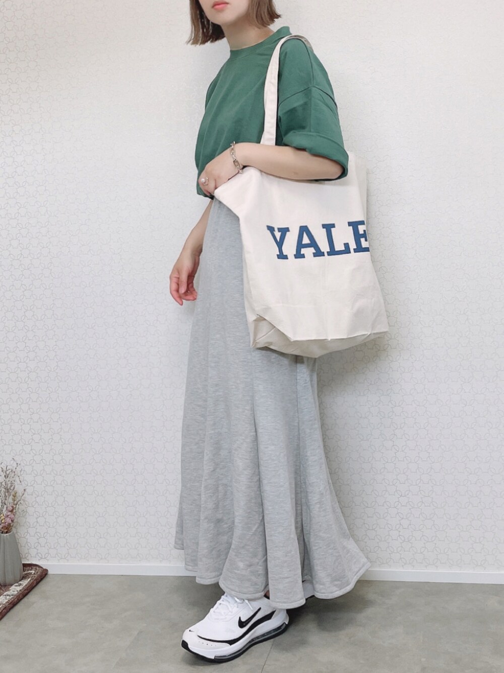 グリーン系のTシャツ/カットソー、ホワイト系のトートバッグ、グレー系のスカートを着用したレディースの春コーディネートの3枚目の写真