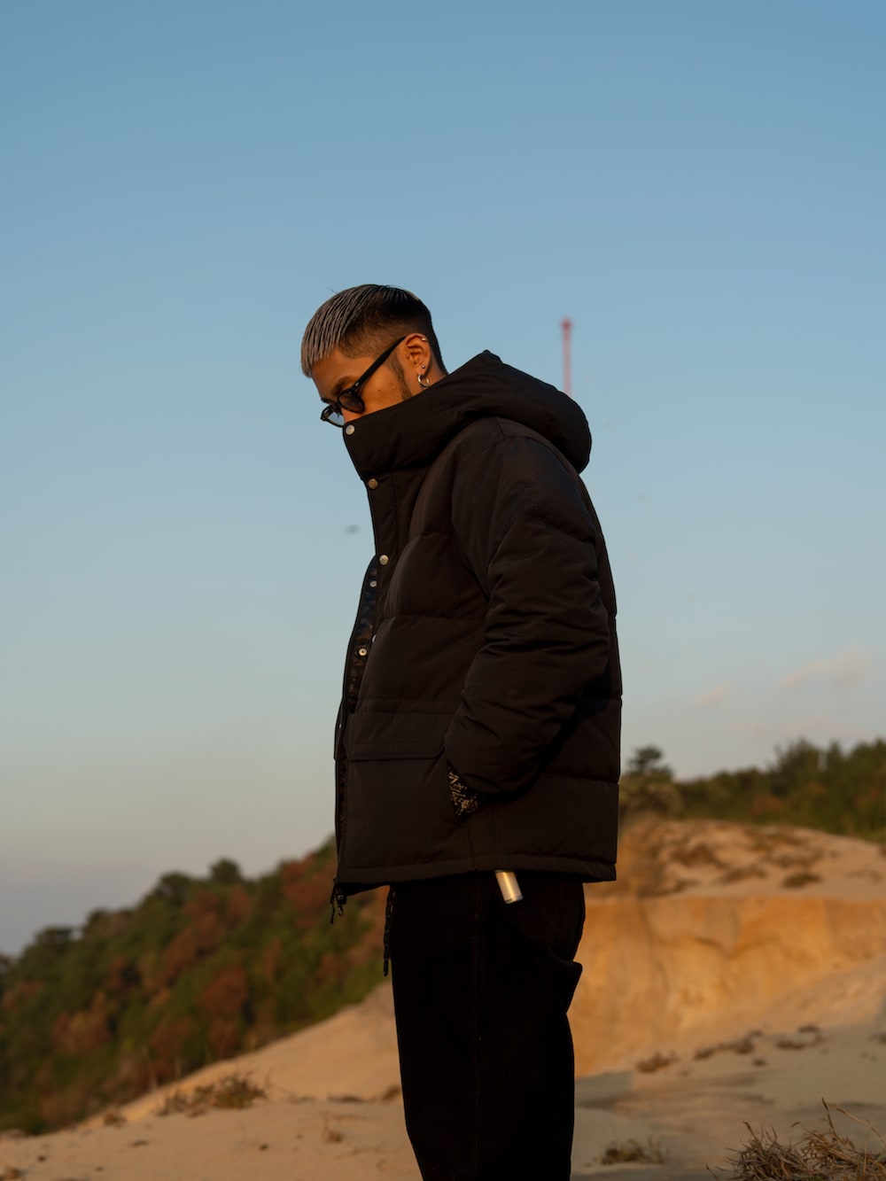 ブラック系のダウンジャケット/コート、ブラック系のその他パンツ、ブラック系のスウェットを着用したメンズの冬コーディネートの2枚目の写真