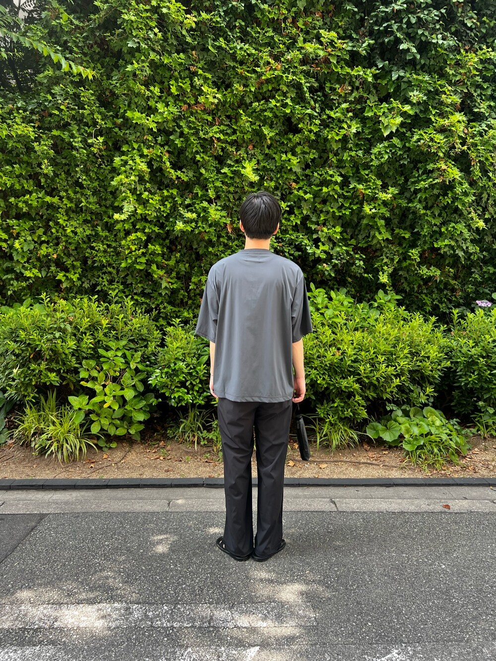 グレー系のTシャツ/カットソー、ブラック系のその他パンツ、ブラック系の折りたたみ傘を着用したメンズの夏コーディネートの4枚目の写真