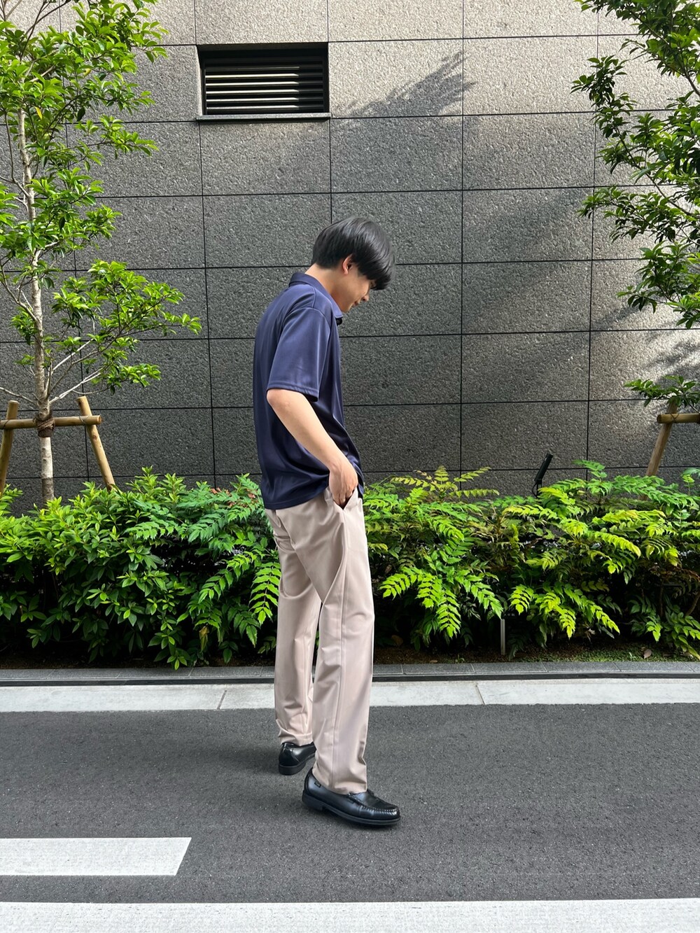 ブルー系のポロシャツ、ベージュ系のパンツを着用したメンズの夏コーディネートの2枚目の写真