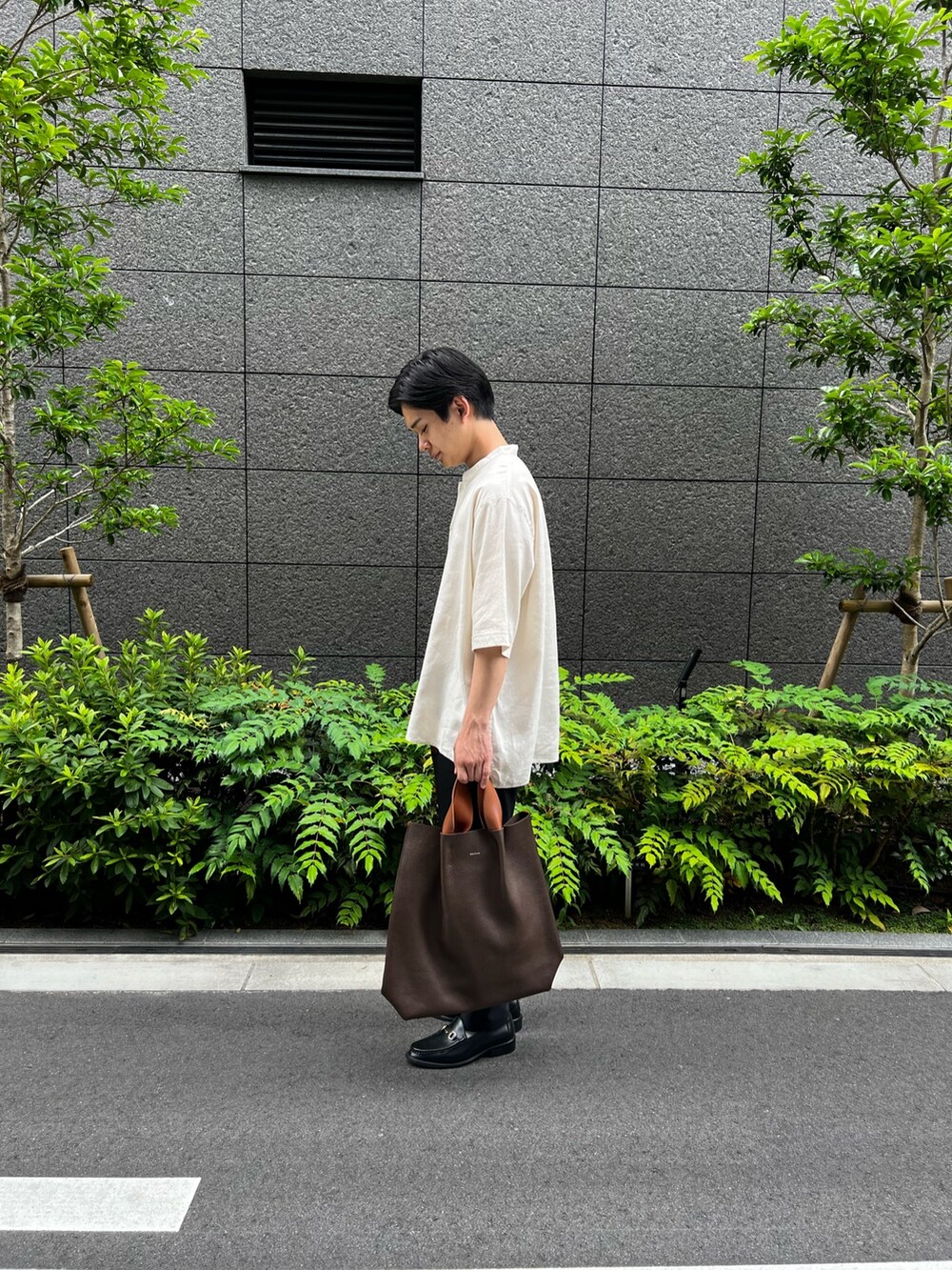 ホワイト系のシャツ/ブラウス、ブラック系のスラックス、ブラウン系のハンドバッグを着用したメンズの夏コーディネートの4枚目の写真