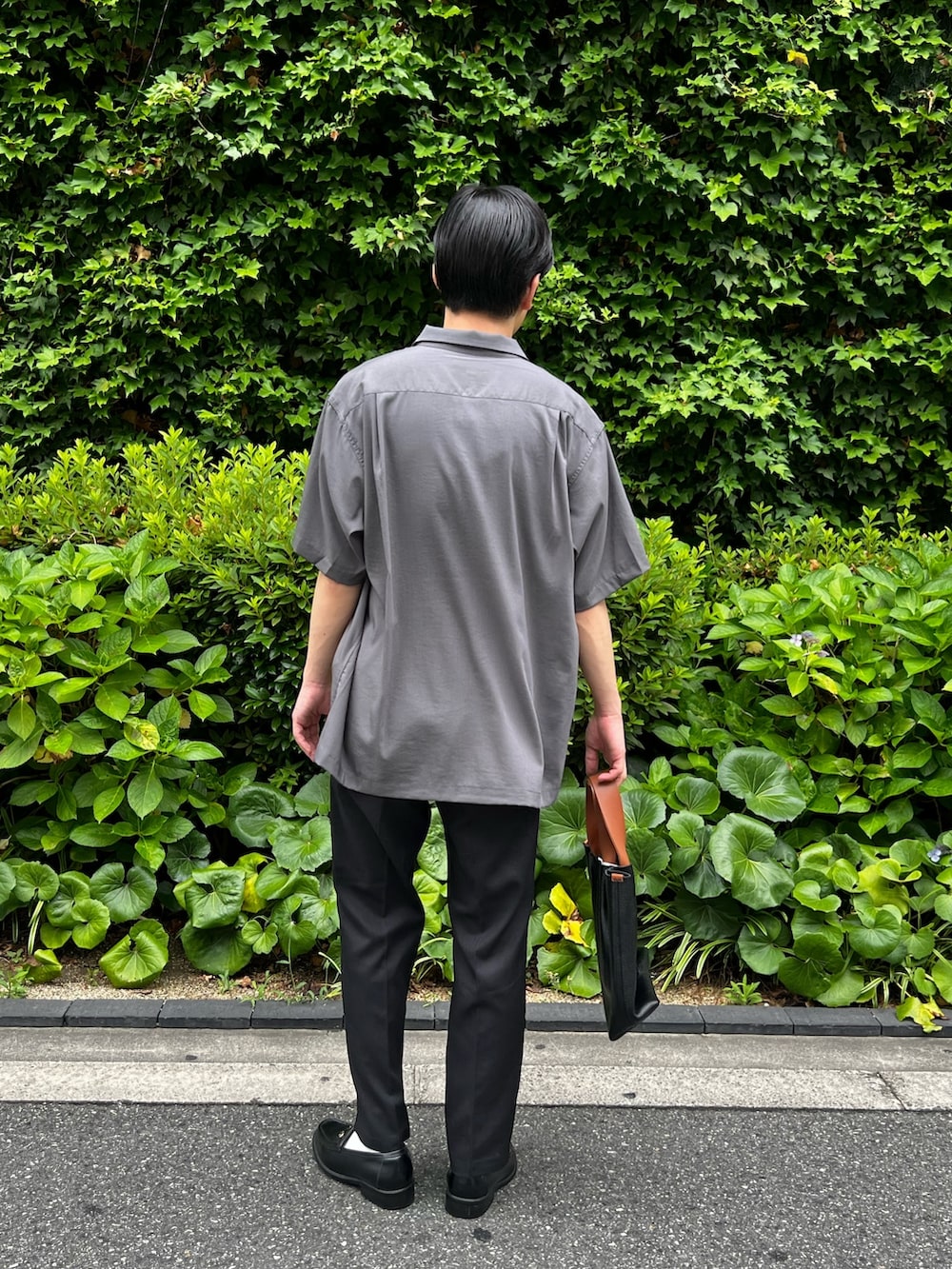 グレー系のシャツ/ブラウス、ブラック系のスラックス、ブラック系のハンドバッグを着用したメンズの夏コーディネートの4枚目の写真
