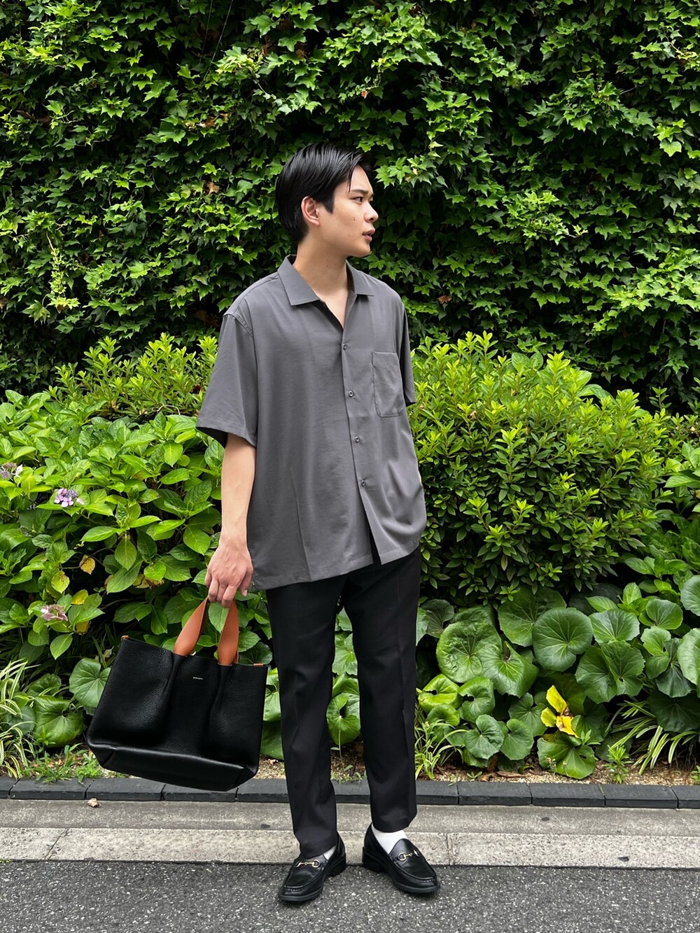 グレー系のシャツ/ブラウス、ブラック系のスラックス、ブラック系のハンドバッグを着用したメンズの夏コーディネートの2枚目の写真