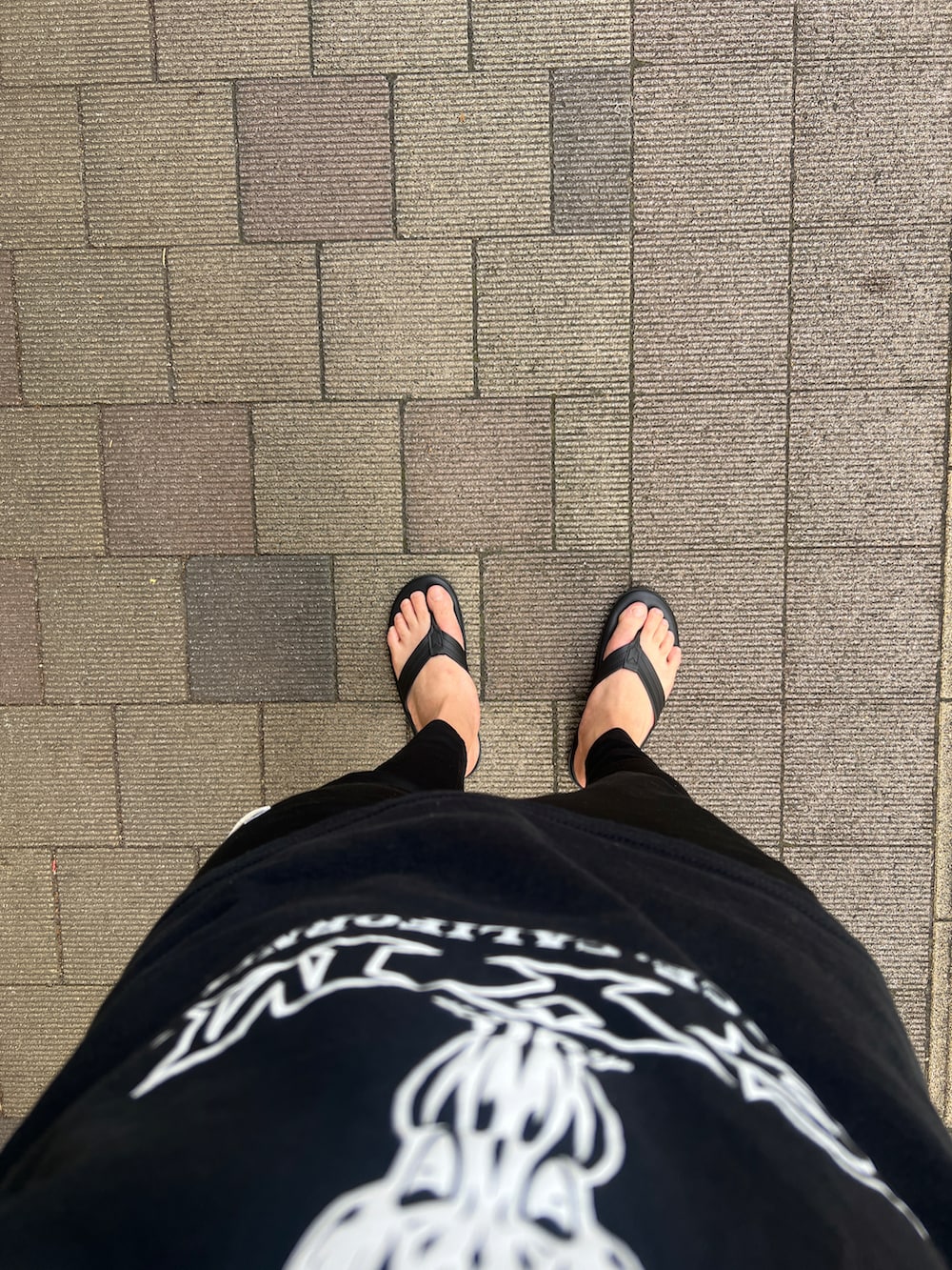 ブラック系のサンダル、ブラック系のスウェットパンツ、ブラック系のTシャツ/カットソーを着用したメンズの夏コーディネートの2枚目の写真