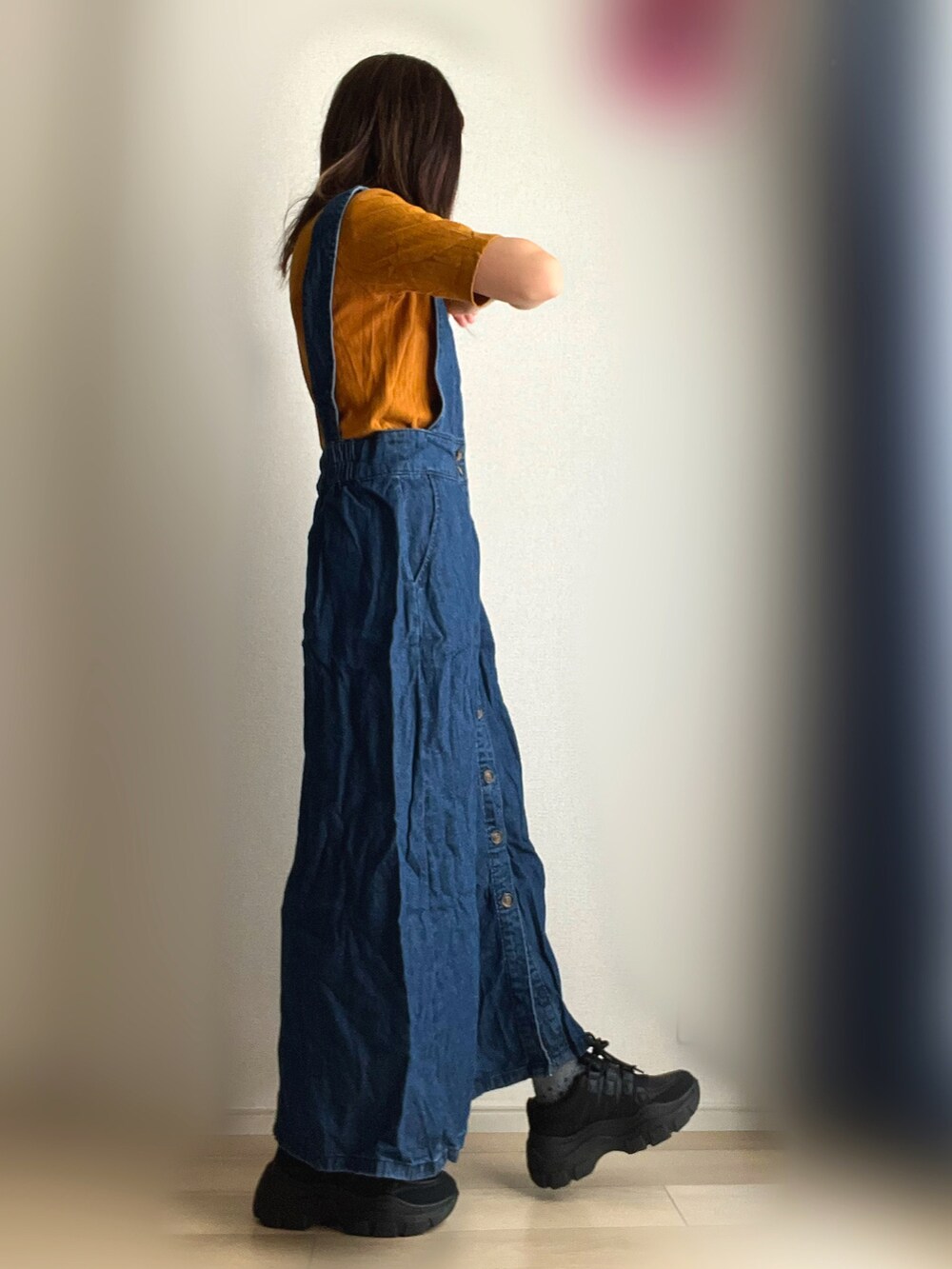 ブルー系のジャンパースカート、ブラック系のスニーカーを着用したレディースの秋コーディネートの3枚目の写真