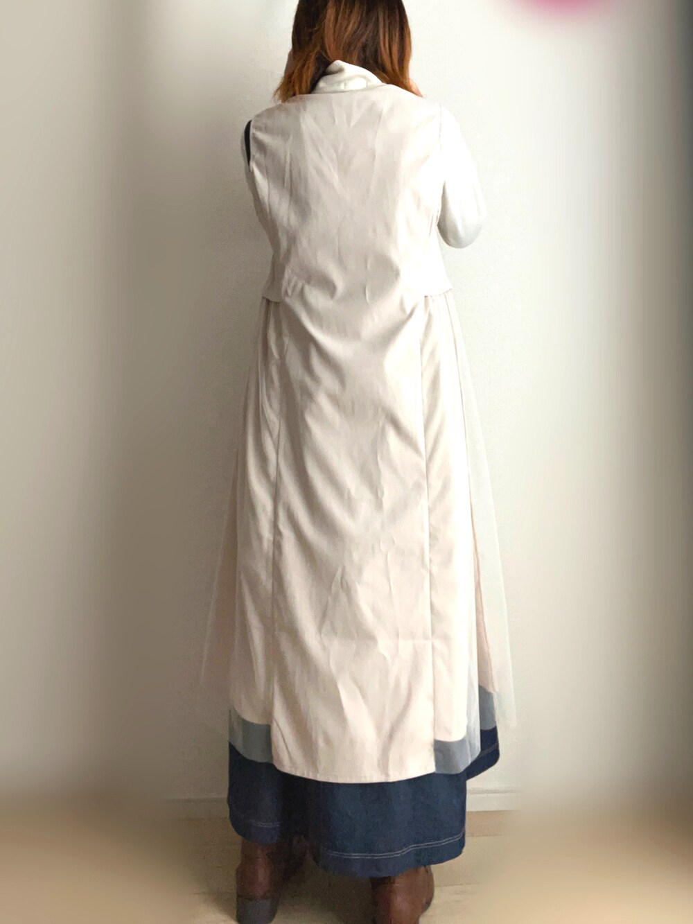 ベージュ系のベスト、ブルー系のワンピースを着用したレディースの秋コーディネートの3枚目の写真