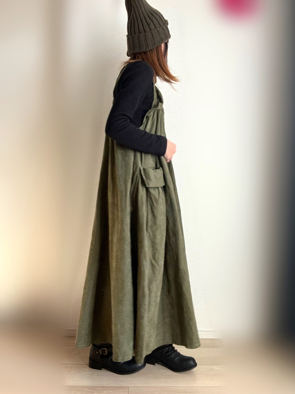 グリーン系のジャンパースカート、ブラック系のTシャツ/カットソーを着用したレディースの冬コーディネートの3枚目の写真