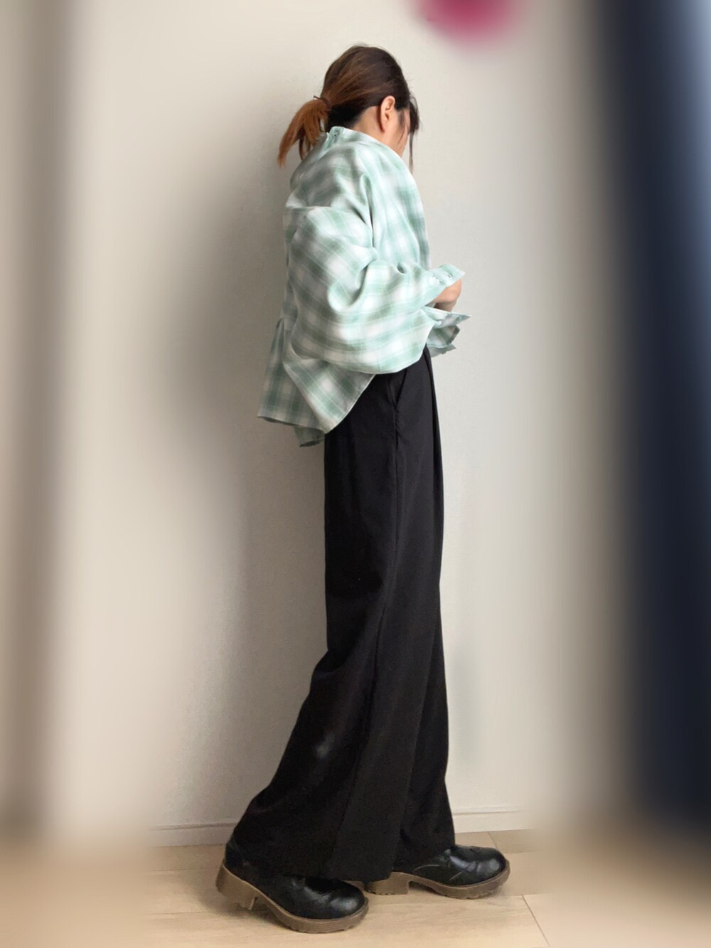 グリーン系のシャツ/ブラウス、ブラック系のスラックスを着用したレディースの春コーディネートの2枚目の写真