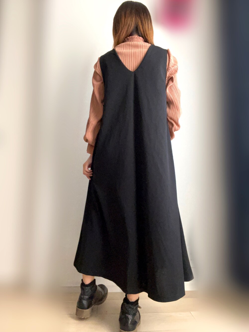 ブラック系のジャンパースカート、オレンジ系のTシャツ/カットソーを着用したレディースの秋コーディネートの3枚目の写真