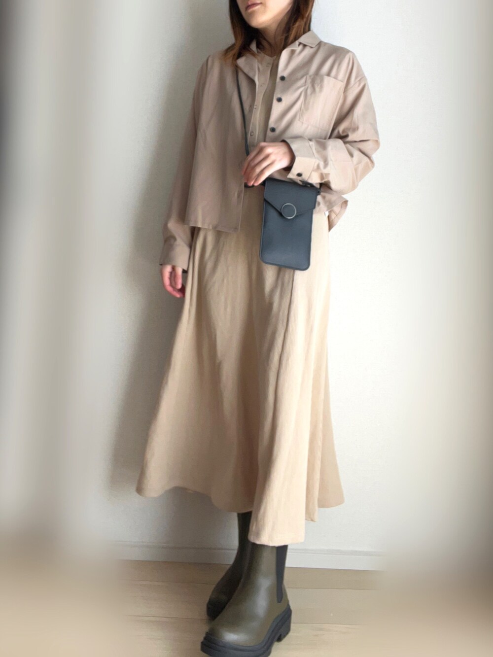 ベージュ系のシャツ/ブラウス、ベージュ系のワンピース、グリーン系のブーツを着用したレディースの春コーディネートの2枚目の写真
