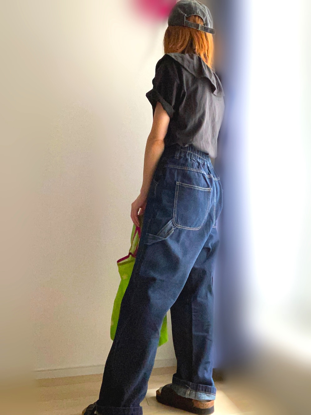 ブラック系のTシャツ/カットソー、ブルー系のデニムパンツ、グリーン系のエコバッグ/サブバッグを着用したレディースの夏コーディネートの2枚目の写真