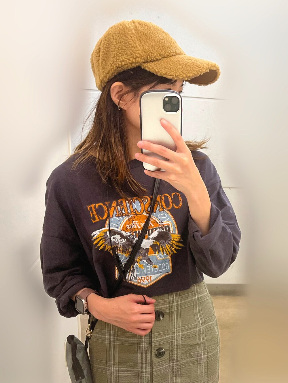 ブラック系のTシャツ/カットソー、グリーン系のスカート、ブラック系のスニーカーを着用したレディースの秋コーディネートの3枚目の写真