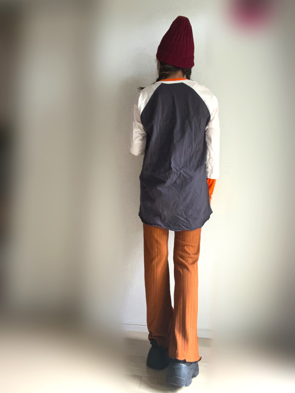 ブラック系のTシャツ/カットソー、ブラック系のスニーカー、オレンジ系のその他パンツを着用したレディースの秋コーディネートの2枚目の写真