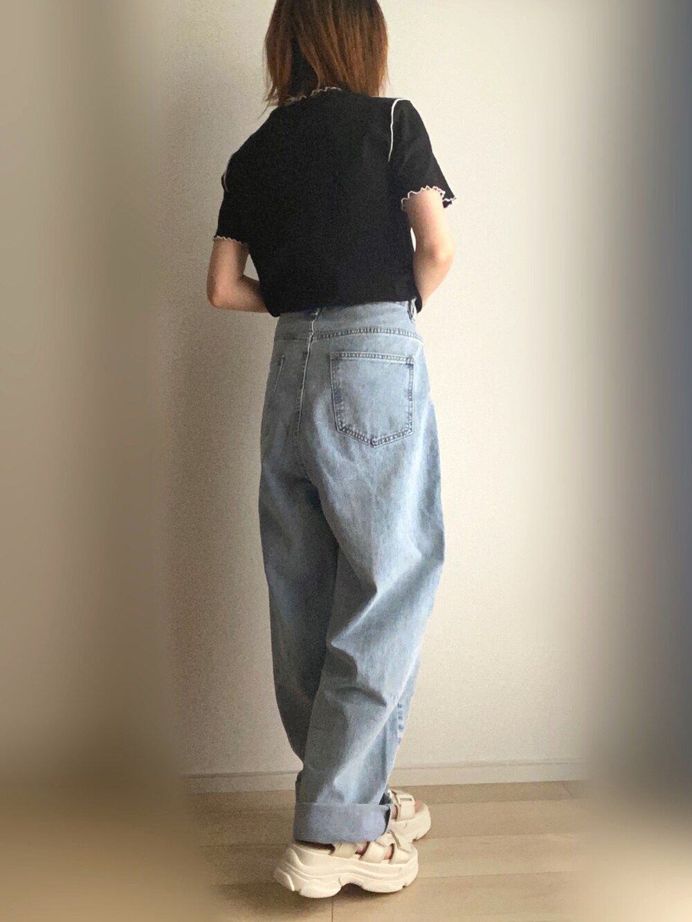 ブラック系のTシャツ/カットソー、ブルー系のデニムパンツ、ホワイト系のサンダルを着用したレディースの夏コーディネートの2枚目の写真