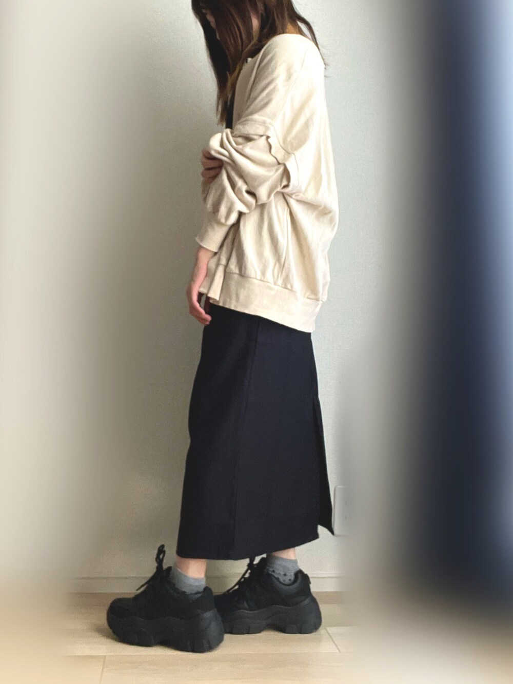 ブラック系のワンピース、ブラック系のスニーカー、ホワイト系のカーディガン/ボレロを着用したレディースの秋コーディネートの2枚目の写真