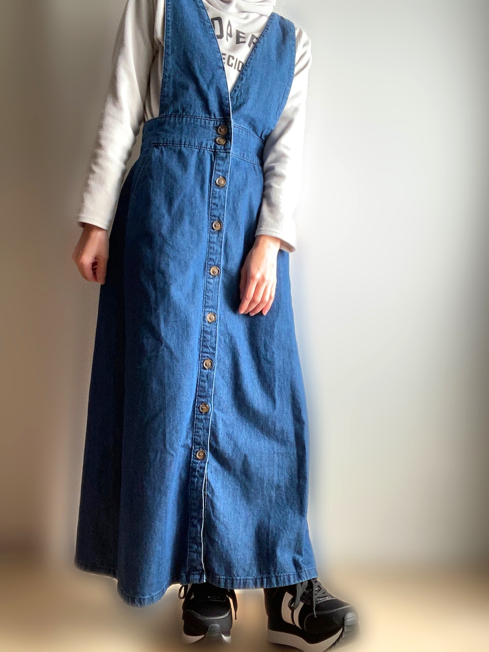 ブルー系のジャンパースカートを着用したレディースの春コーディネートの2枚目の写真