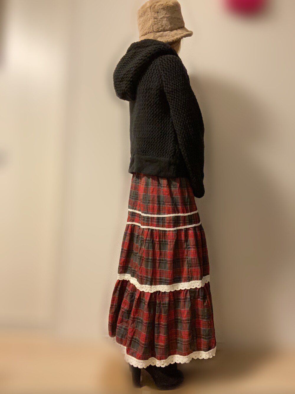 ブラック系のポンチョ、レッド系のスカートを着用したレディースの冬コーディネートの3枚目の写真