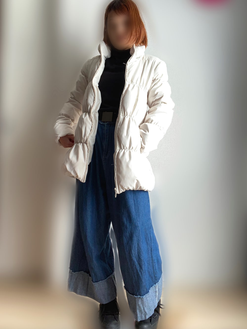 ホワイト系のダウンジャケット/コート、ブルー系のデニムパンツ、ブラック系のスニーカーを着用したレディースの冬コーディネートの2枚目の写真