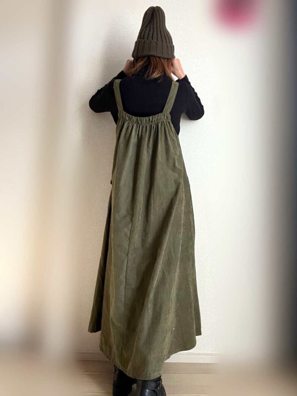 グリーン系のジャンパースカート、ブラック系のTシャツ/カットソーを着用したレディースの冬コーディネートの4枚目の写真