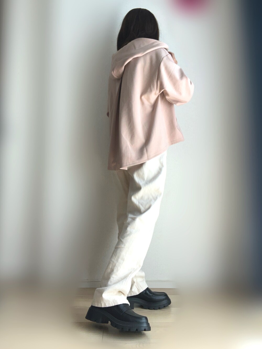 ベージュ系のデニムパンツ、ブラック系のローファー、ベージュ系のパーカーを着用したレディースの冬コーディネートの3枚目の写真