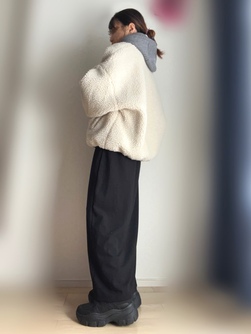 ベージュ系のブルゾン、ブラック系のワンピース、ブラック系のスニーカーを着用したレディースの冬コーディネートの2枚目の写真