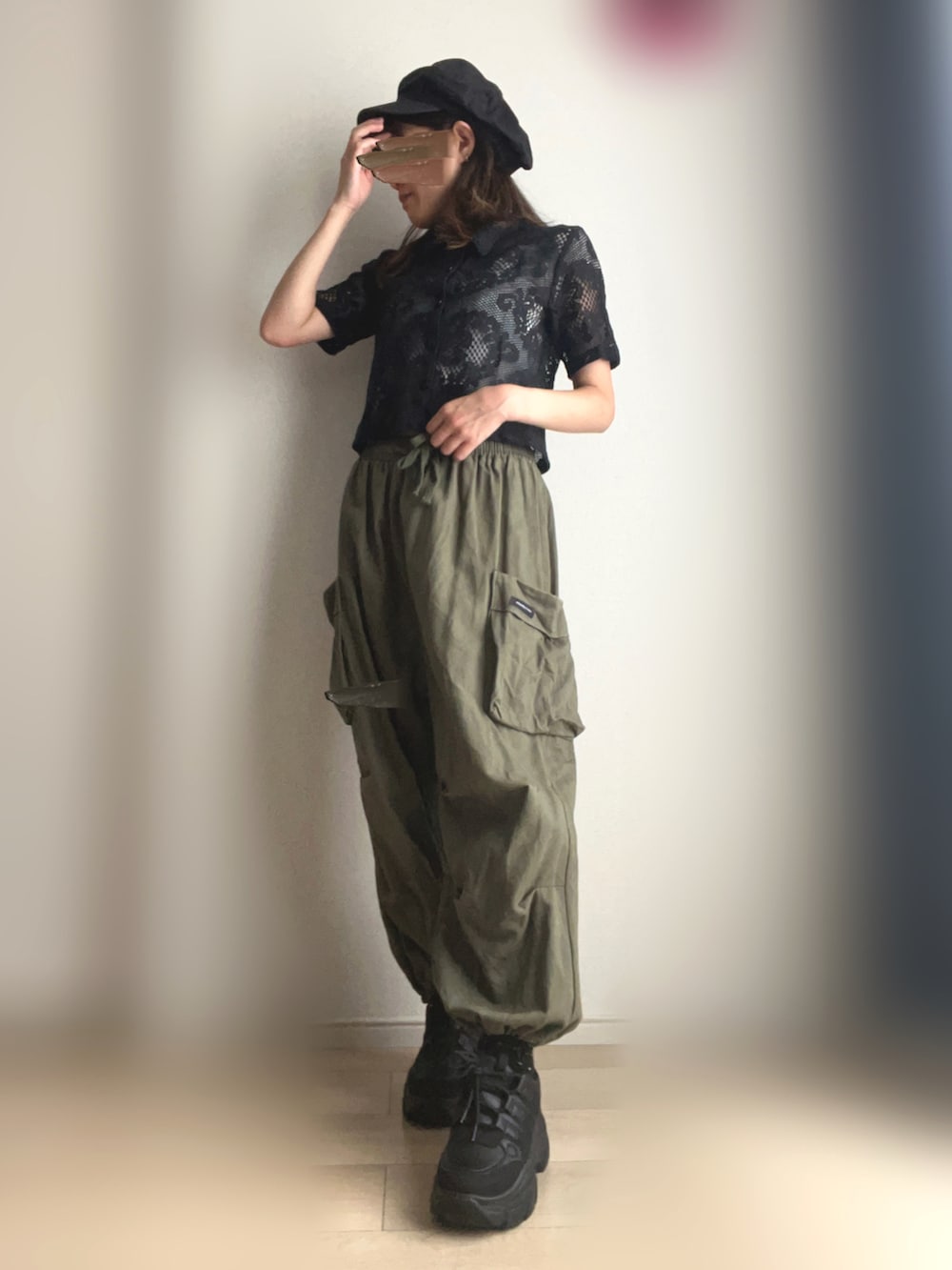 グリーン系のカーゴパンツ、ブラック系のスニーカーを着用したレディースの夏コーディネートの2枚目の写真