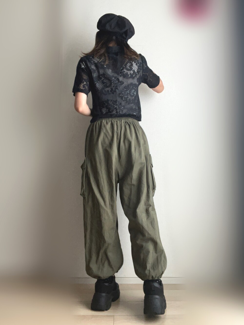 グリーン系のカーゴパンツ、ブラック系のスニーカーを着用したレディースの夏コーディネートの4枚目の写真