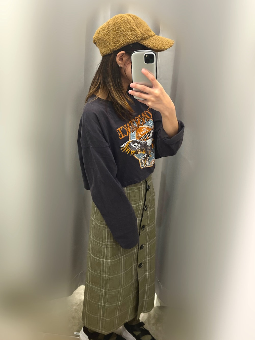 ブラック系のTシャツ/カットソー、グリーン系のスカート、ブラック系のスニーカーを着用したレディースの秋コーディネートの2枚目の写真