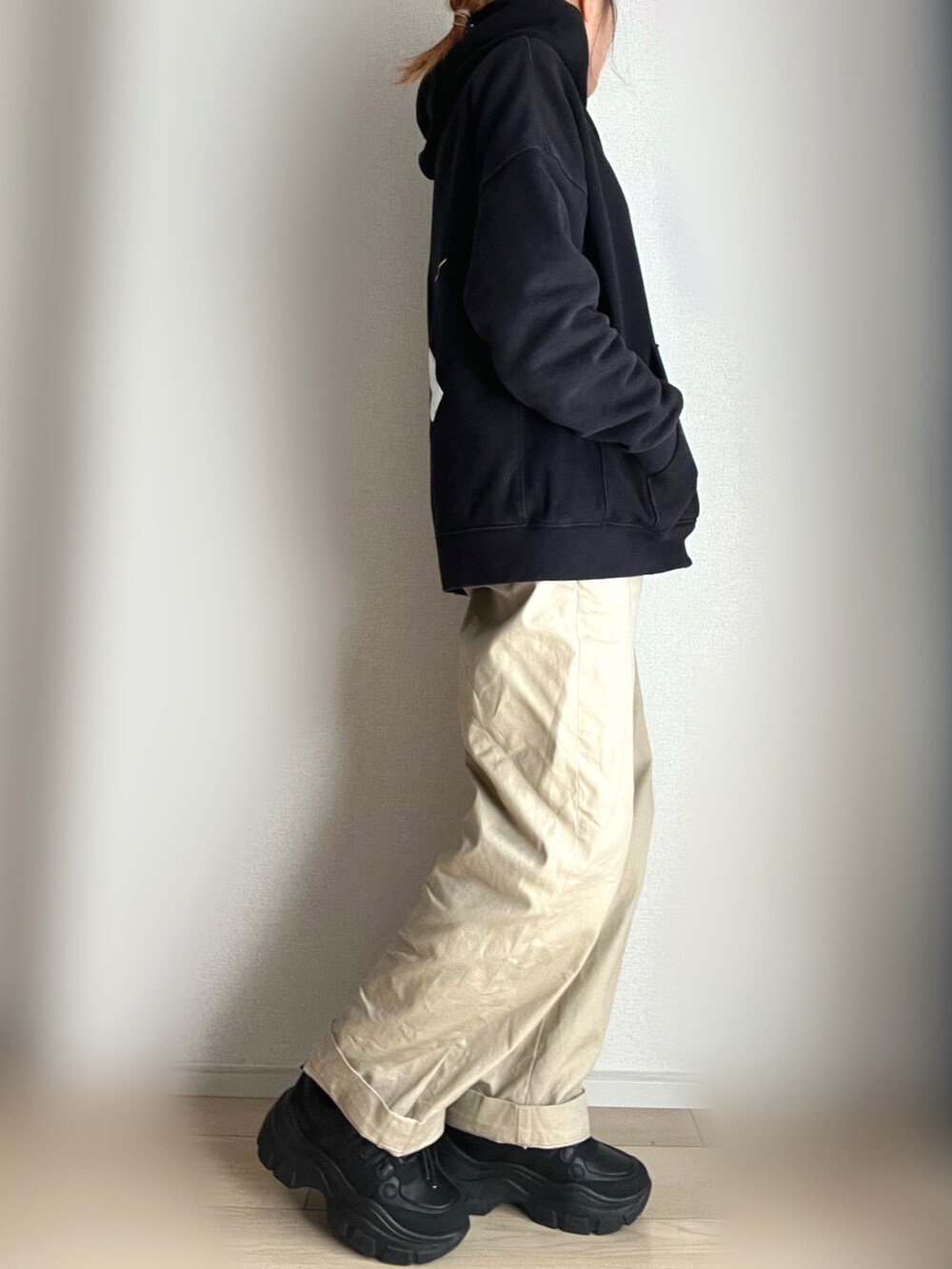 ベージュ系のチノパンツ、ブラック系のスニーカー、ブラック系のパーカーを着用したレディースの冬コーディネートの2枚目の写真