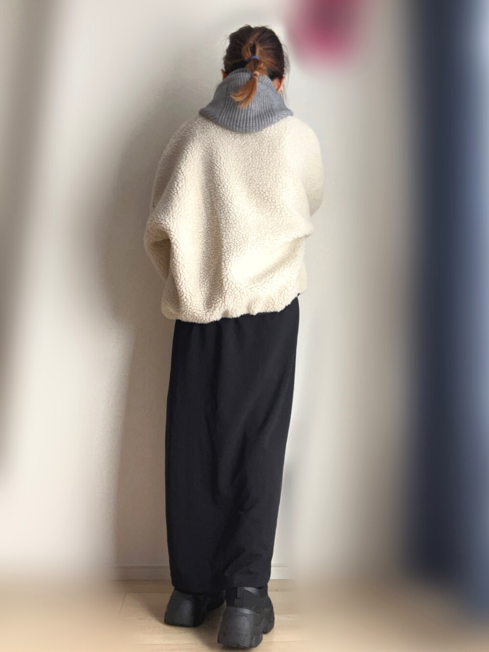 ベージュ系のブルゾン、ブラック系のワンピース、ブラック系のスニーカーを着用したレディースの冬コーディネートの3枚目の写真