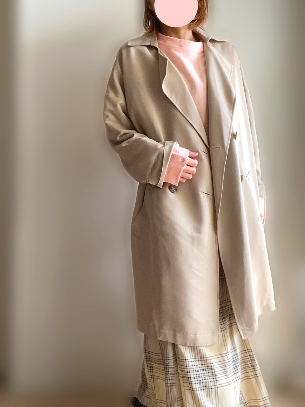 ベージュ系のトレンチコート、ホワイト系のスカートを着用したレディースの春コーディネートの2枚目の写真