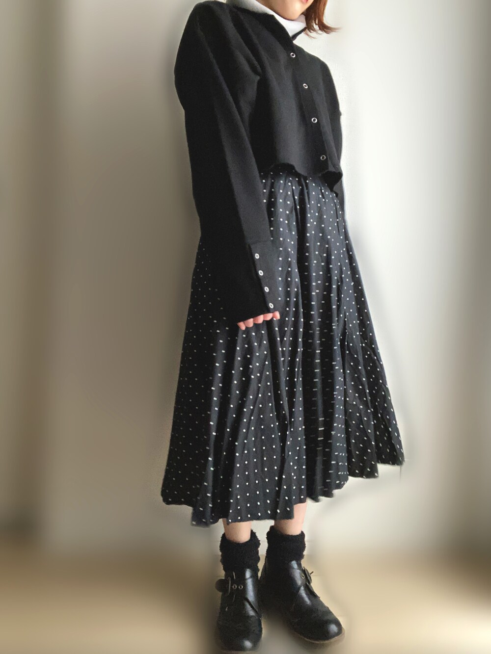 ブラック系のカーディガン/ボレロ、ブラック系のスカートを着用したレディースの春コーディネートの2枚目の写真