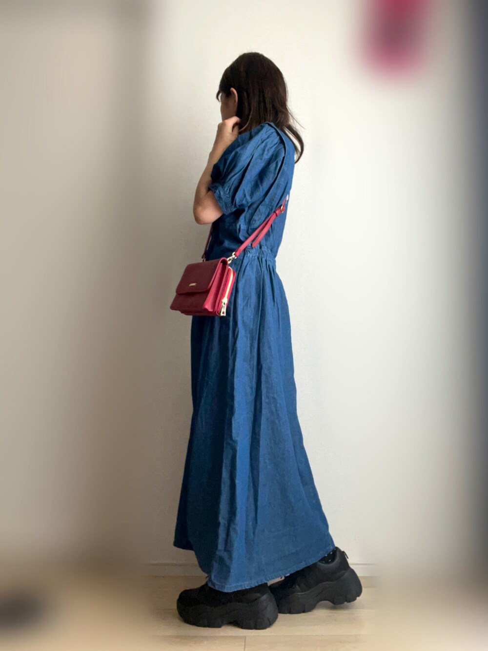 ブルー系のワンピース、レッド系のショルダーバッグ、ブラック系のスニーカーを着用したレディースの夏コーディネートの2枚目の写真