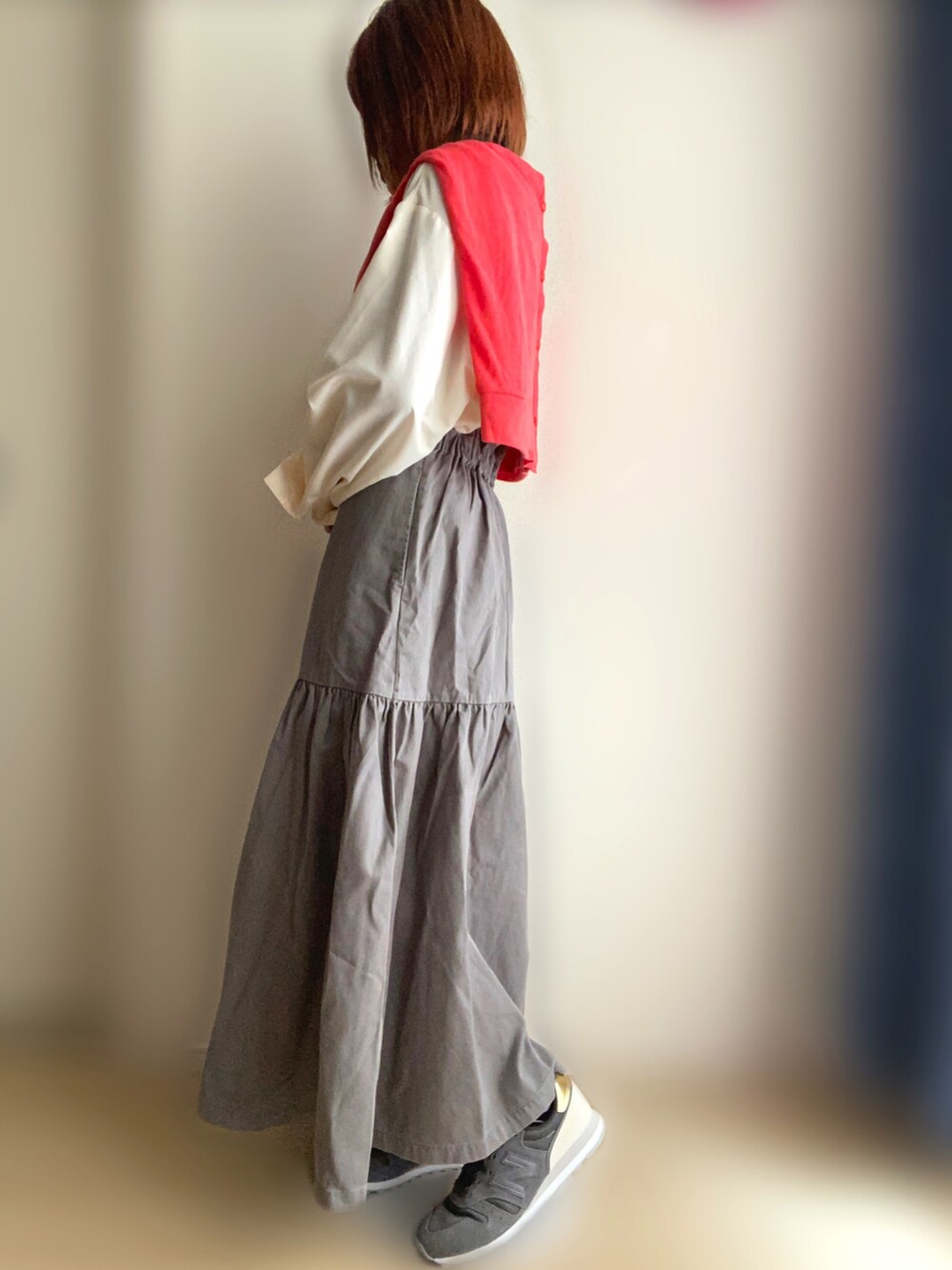 グレー系のジャンパースカート、ホワイト系のシャツ/ブラウス、グレー系のスニーカーを着用したレディースの春コーディネートの3枚目の写真